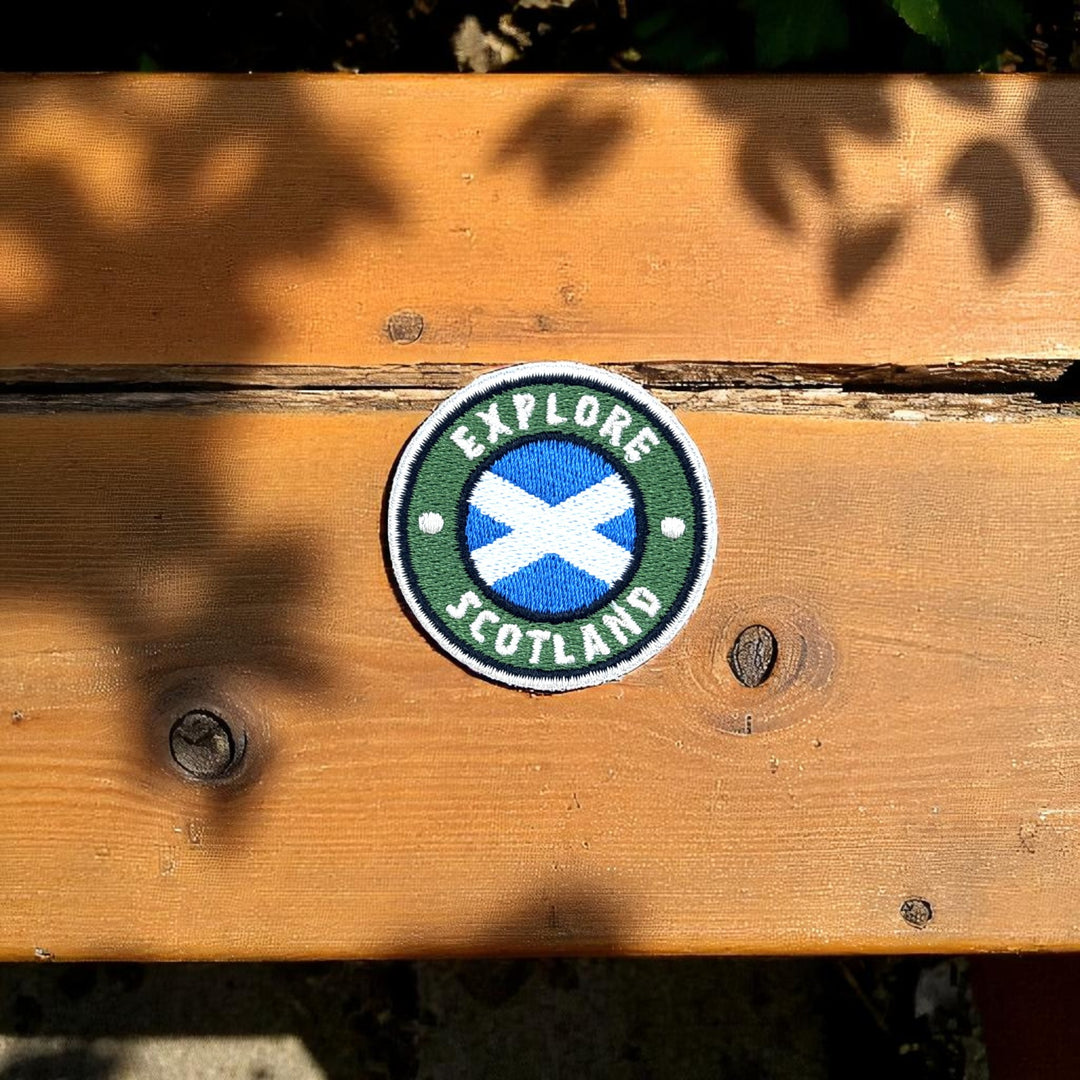 Big Country Round Explore Scotland Patch on wooden bench