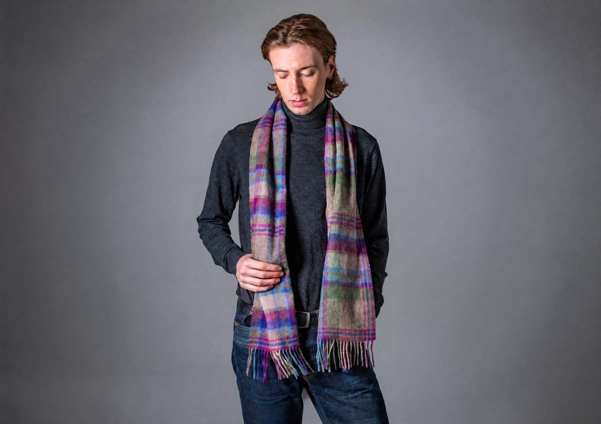 Man wearing a pure wool tartan scarf over a dark roll-neck jumper