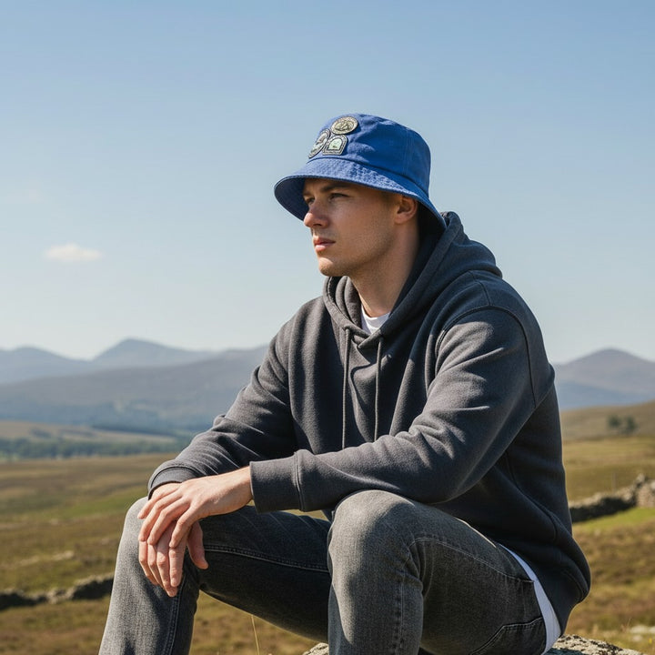 Man wearing blue bucket hat in Scottish countryside