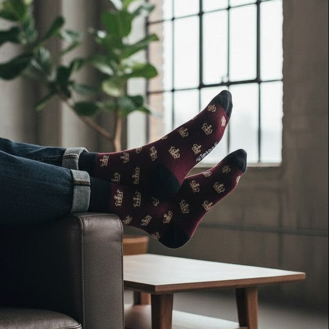 Person relaxing on a couch with feet up, wearing patterned socks in a home setting.